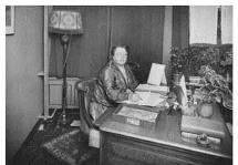 Rosa Manus achter haar bureau