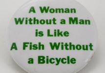 Witte button met in het groen de tekst: 'A Woman Without a Man is Like A Fish Without a Bicycle'. 