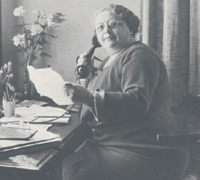 Rosa Manus achter bureau